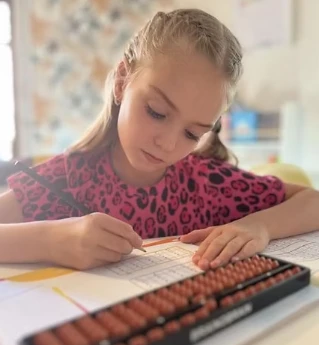 Fillette concentrée utilisant un boulier lors d'un cours de calcul mental à l'Active Brain Kids Academy