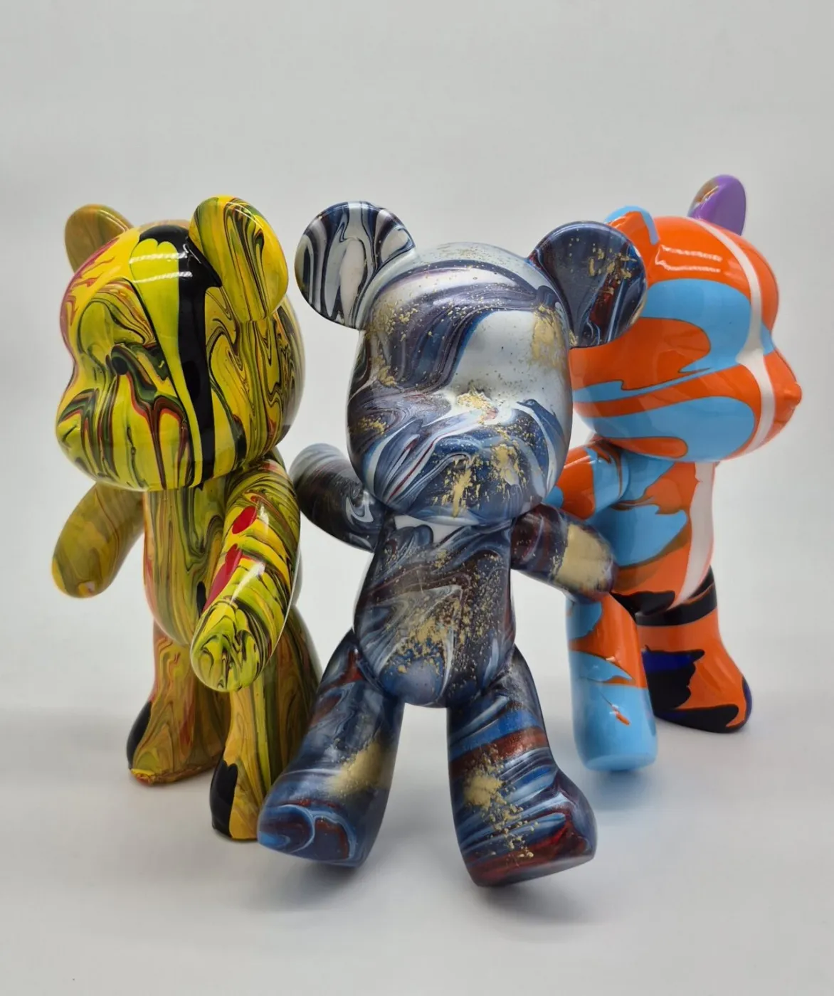 Trois figurines ours peintes en fluid painting aux couleurs vives, jaune, bleu et orange, Studio Fluid Painting Genève