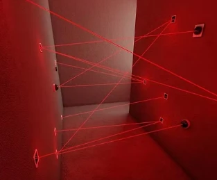 Salle labyrinthe laser rouge du Cube Challenge à Genève, avec faisceaux lumineux à éviter