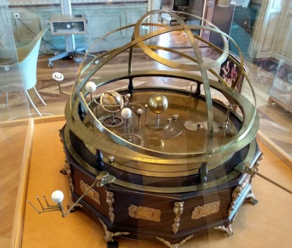 Sphère armillaire et orrery anciens en laiton exposés sous vitrine au Musée d'histoire des sciences de Genève