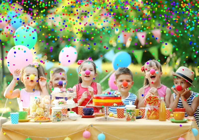 Groupe d'enfants joyeux autour d'un gâteau d'anniversaire, avec ballons colorés et confettis