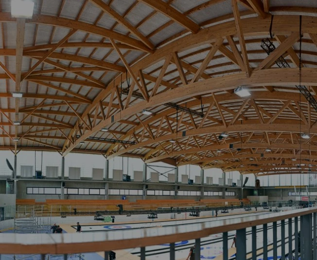 Vue intérieure de la patinoire couverte de Sous-Moulin à Thônex, avec sa charpente en bois et sa piste de glace