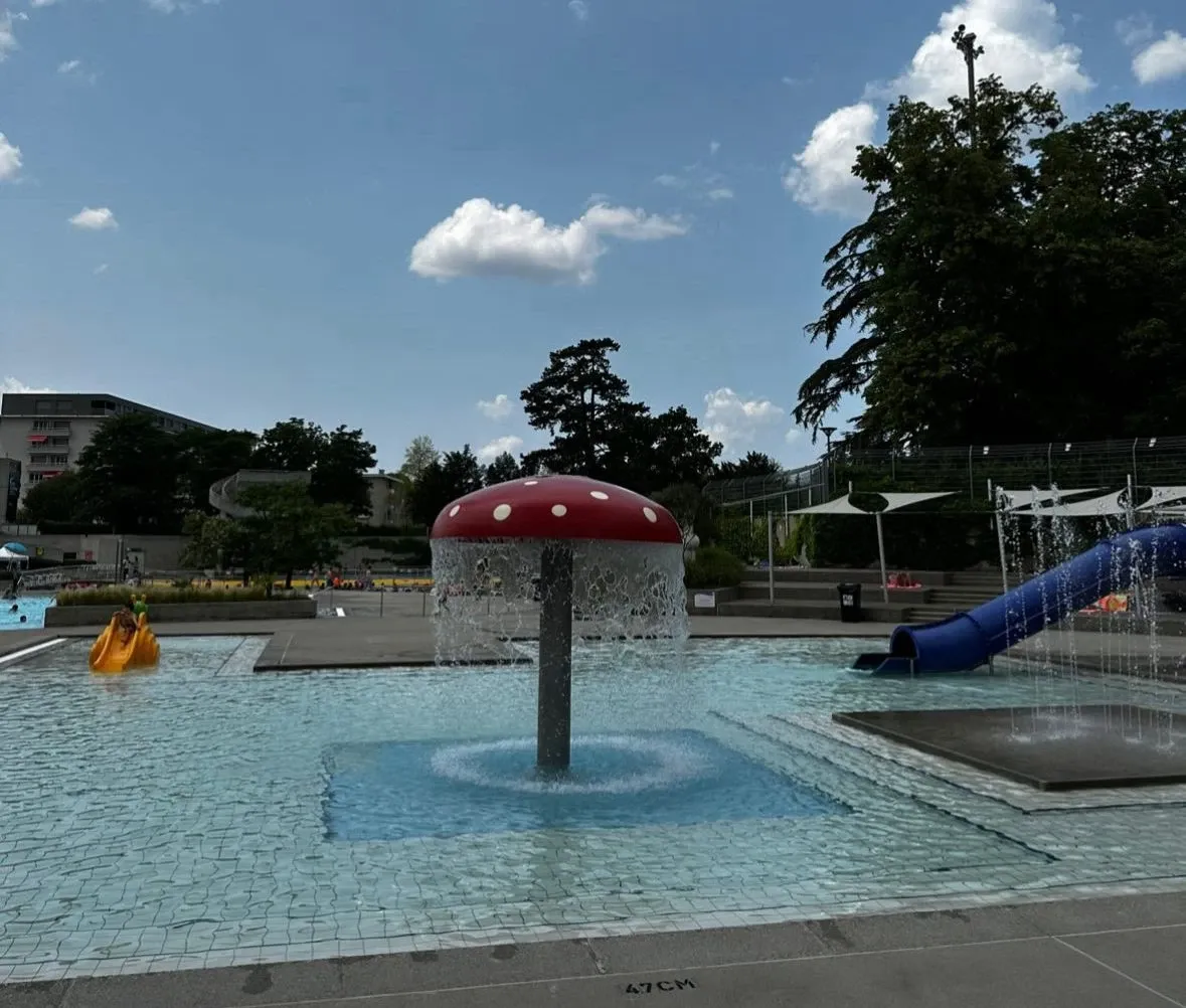 Pataugeoire de la piscine de Marignac avec la fontaine champignon et un toboggan bleu, Grand-Lancy