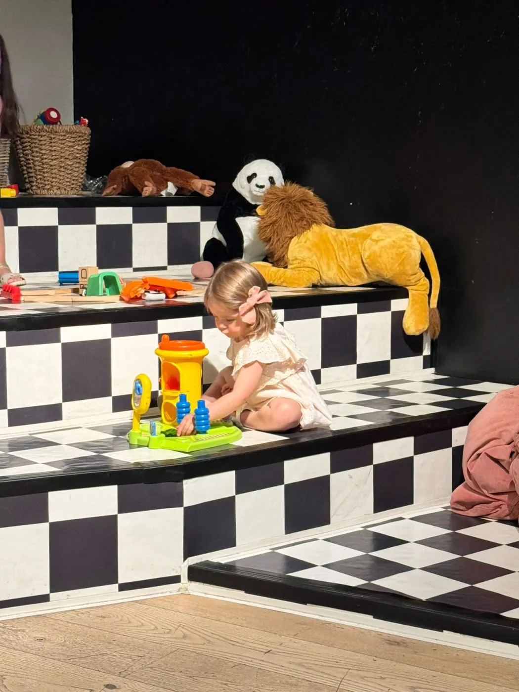 Petite fille jouant avec des jouets colorés dans l'espace enfants du bistrot Home à Meyrin