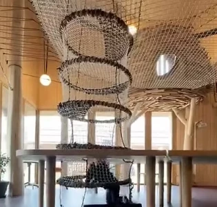 Espace de jeux La Canopée avec filets suspendus et toboggans en bois à la Rôtisserie de la Ferme