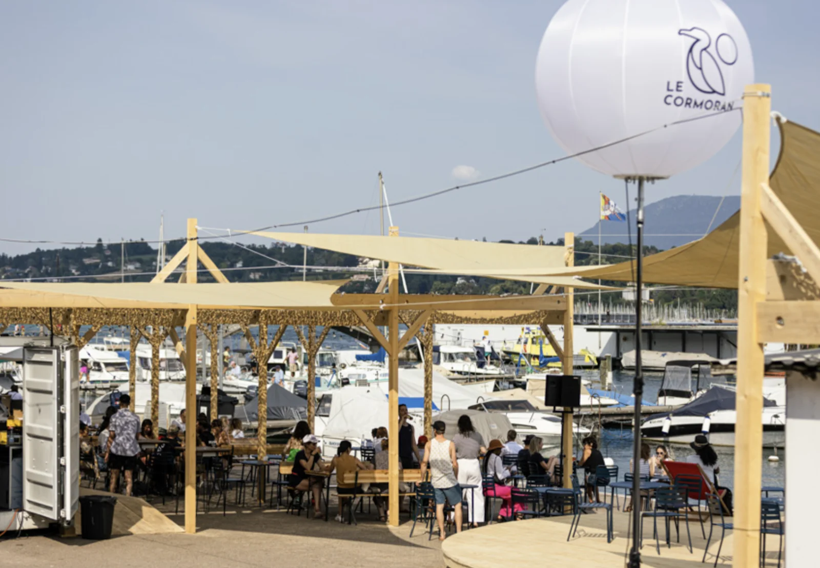 Terrasse du Cormoran au bord du lac à Genève, avec voilures tendues et bateaux en arrière-plan