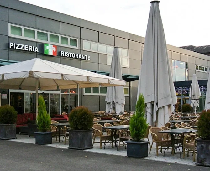 Terrasse avec parasols de la Pizzeria Ristorante Molino à Thônex, façade moderne