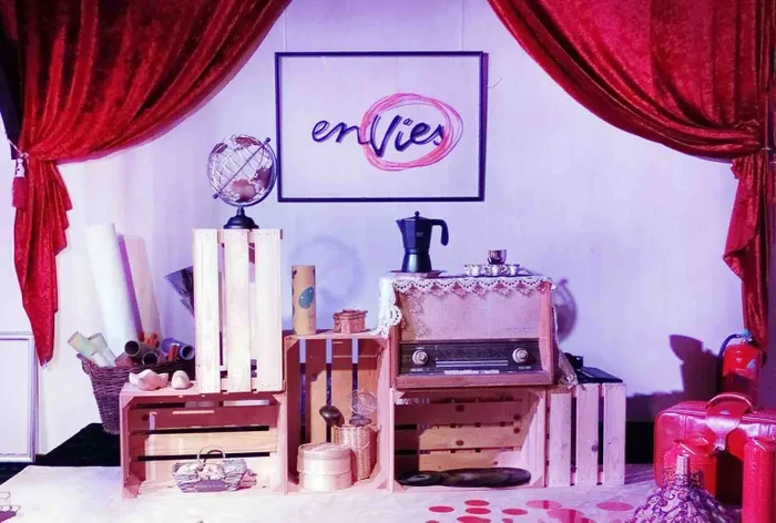 Mise en scène du Cabinet d’Émerveille de l’association enVies : caisses en bois, radio ancienne, globe et rideaux rouges