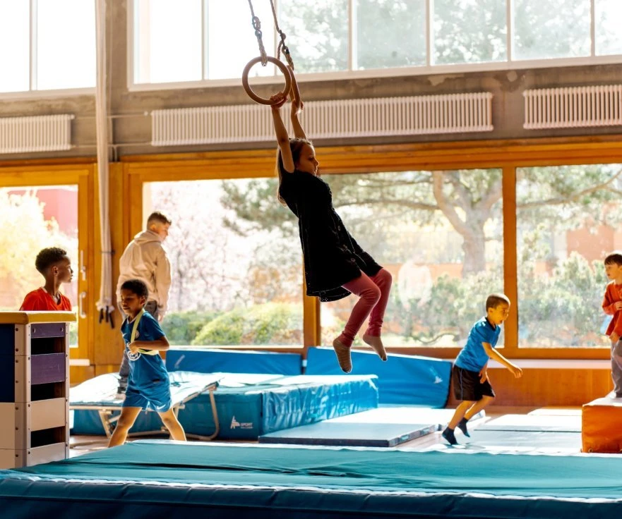 Enfants pratiquant la gymnastique dans une salle sportive lors de l'Open Sunday Onex